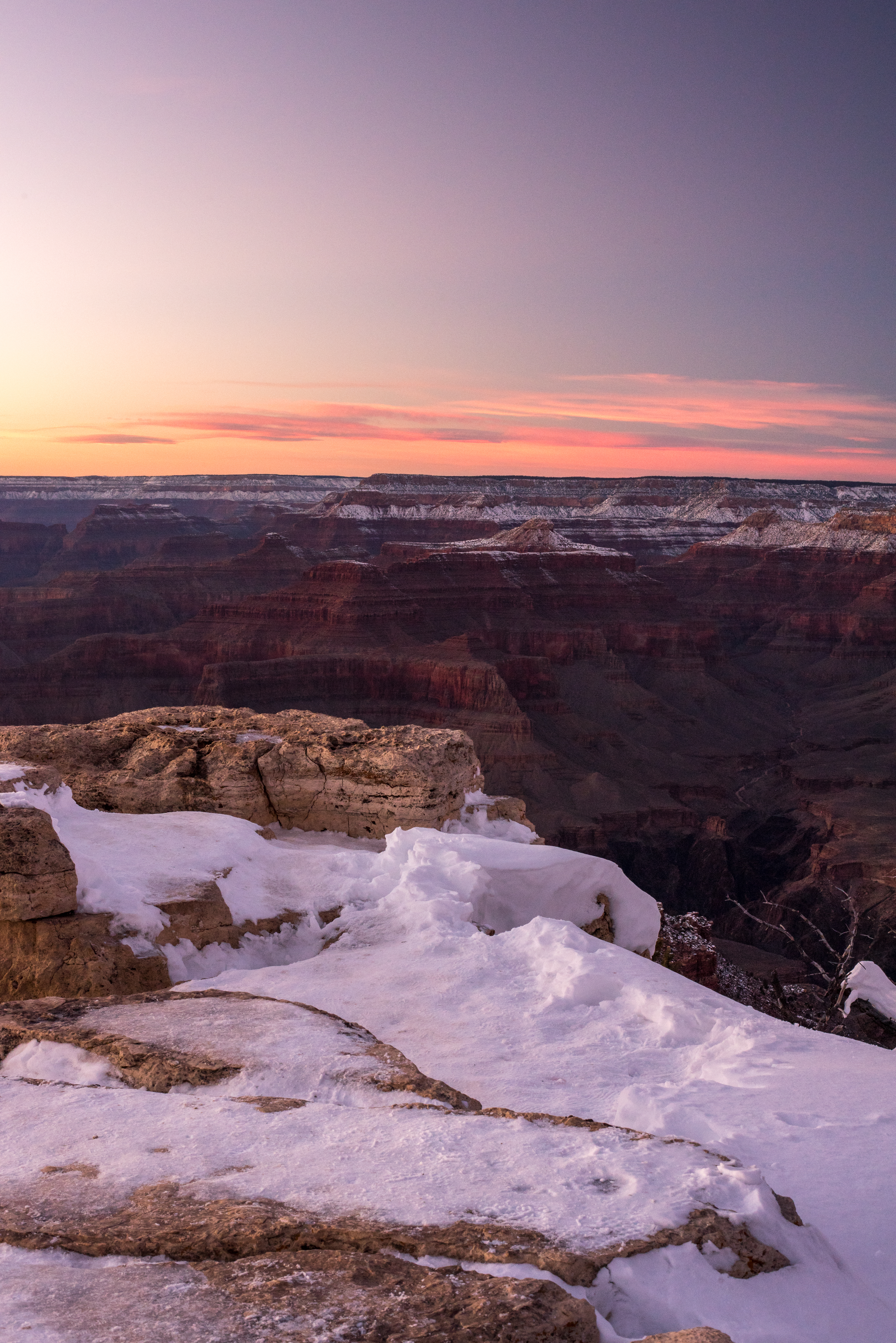 A photo of the Grand Canyon with snow at sunset